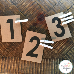 A simple math center for primary students using Kraft paper scrapbook paper and white clothespins! 